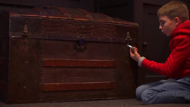 a boy at a school competition opens a combination lock on a chest