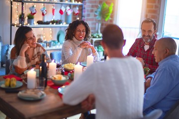 Beautiful family smiling happy and confident. Eating roasted turkey celebrating Christmas at home
