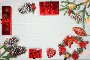 christmas decoration and red gift boxes on white wooden background