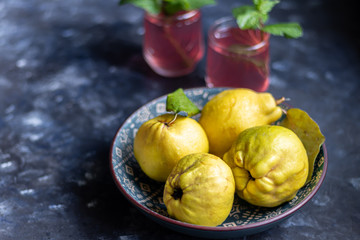 The fruits of quince. They differ in their useful properties. Suitable for food in baked, boiled form. Have a yellow color. Fruit campot in the background. Horizontal layout. Copy space. 