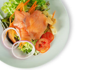 A delicious smoked salmon garden salad with smoked salmon, mixed baby greens, red and yellow cherry tomatoes on white or isolated bbakground.