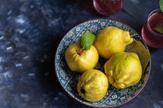 The fruits of quince. They differ in their useful properties. Suitable for food in baked, boiled form. Have a yellow color. Fruit campot in the background. Horizontal layout. Copy space. 