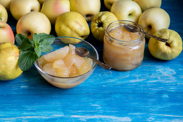The fruits of apples and quinces. They differ in their useful properties. Suitable for food in baked, boiled form. Have a yellow color. Near jam of these fruits. Horizontal location. Copy space. 