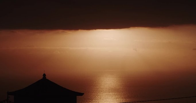 Magnificent sunset. Orange golden sky and shining sea. View of gorgeous yellow sun coing out of clouds. Sunset sky at seaside. Time-lapse.