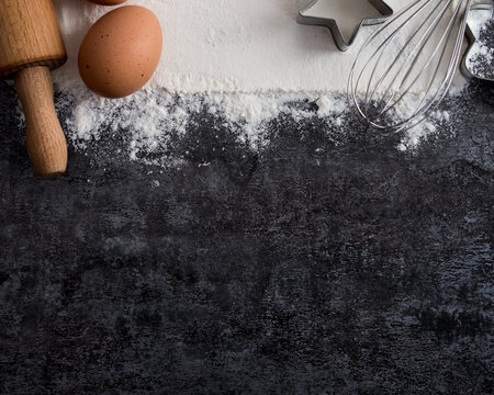 Baking ingredients for christmas cookies on dark background