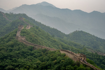 Naklejka premium Great Wall of China with a green trees in a background.