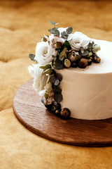 Fototapeta na wymiar White wedding cake decorated with eustoma and eucalyptus flowers. Place for text.