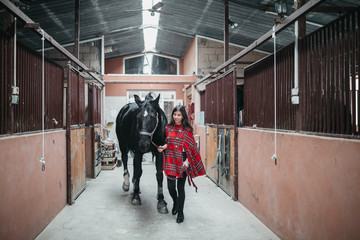 Girl with a horse at the stables
