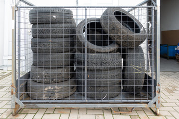 Many old tyres pile up in front of a garage to be disposed of.