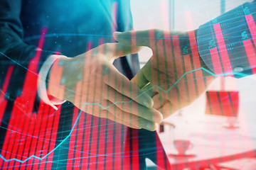 Multi exposure of financial graph on office background with two businessmen handshake. Concept of success in business