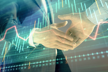 Multi exposure of forex graph on abstract background with two businessmen handshake. Concept of success on stock market