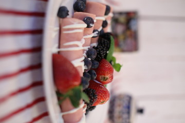 Rolls of canned ham stuffed with cheese served with seasonal fruit. Tasty traditional food