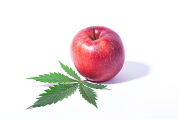 concept: marijuana and healthy eating,cannabis leaf and red apple on a white background