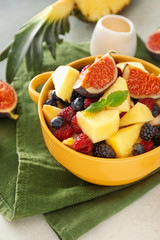 Pot with tasty fruit salad on table