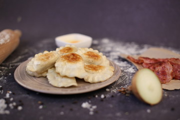 Traditional Russian dumplings stuffed with cheese, potatoes and bacon fried in a pan