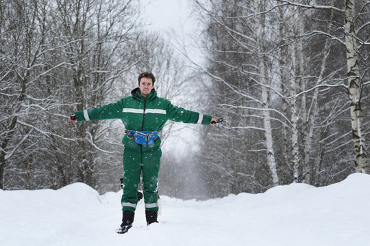 A man standing at snowy road outdoors in winter