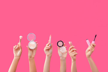 Many hands with decorative cosmetics on color background