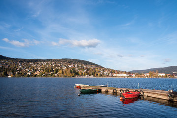 Fototapeta na wymiar Des bateaux sur le lac de Gérardmer. Le lac de Gérardmer en automne. Des bateaux sur un lac.