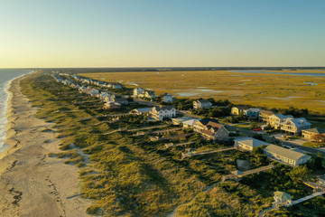 Looking down the coastline of Oak Island NC. Dune and beach houses in view. © Rick