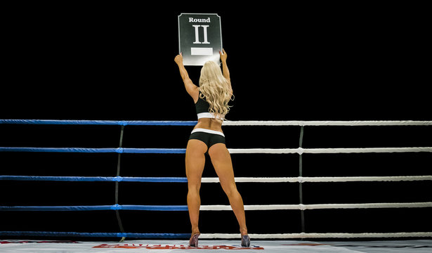 back boxing ring girl carrying sign that displays number of upcoming round