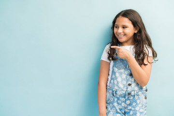Female Child Gesturing Against Plain Background