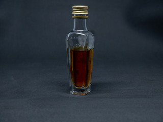bottle and glass of brandy on black background
