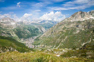 Fototapeta na wymiar Beautiful panoramic view of Val d'Isere France - captured from Col de l'Iseran road. Amazing sunny day. Green background HD. Wallpaper 4k.