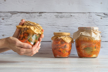 Korean kimchi in jars on a wooden table.