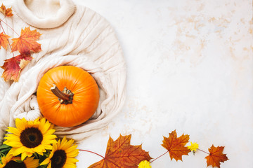 Naklejka na ściany i meble Autumn flat lay background with pumpkin , sweater and golden sunflowers on wooden table. Top view, blank space