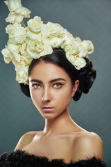 Creative fashion beauty. Portrait of beautiful young woman with flowers hairstyle. Model young woman with professional makeup