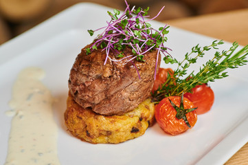 Grilled beef steak served with tomatoes and herbs