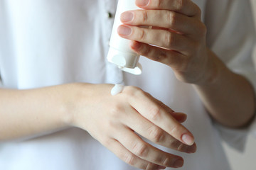 girl uses hand cream. Skin care, skin hydration.