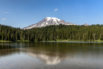 Mount Rainier, Washington State, reflected in the reflection pools in the national park.  It is high summer and the sky is clear blue