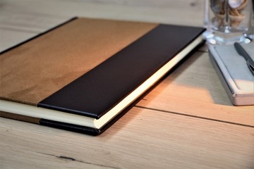 notebook on wooden table with coffee and pen