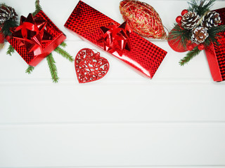 christmas decoration and red gift boxes on white wooden background