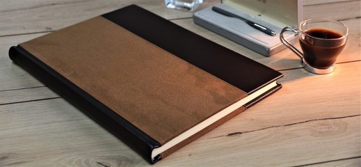 notebook on wooden table with coffee and pen