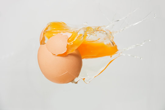 cracked egg with yolk on white background