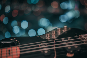 Electric bass guitar blurred background with beautiful bokeh. - obrazy, fototapety, plakaty