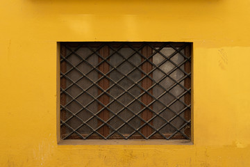 Vintage window with iron grating on a stone wall. Valencia, Spain