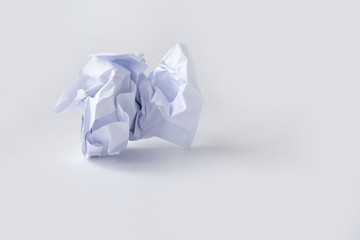 A clump of crumpled white paper on a white background.