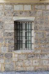 Vintage window with iron grating on a stone wall. Valencia, Spain
