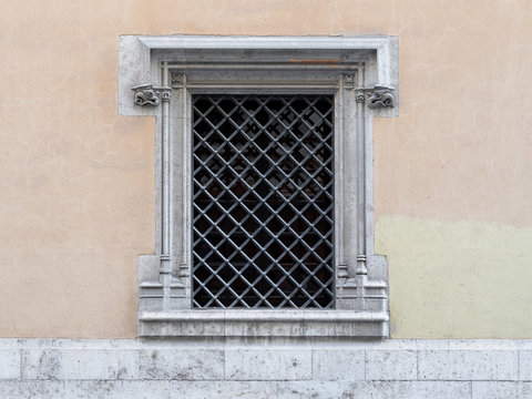 Vintage window with iron grating on a stone wall. Valencia, Spain