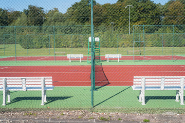 terrain de tennis vide avec filet et grillage et bande