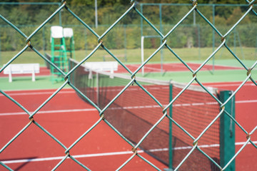 terrain de tennis vide avec filet et grillage et bande