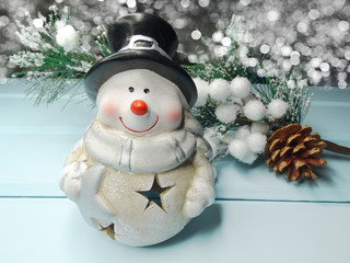 christmas snowman on fir tree branch with cones and snow on background