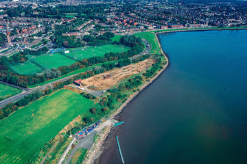Obraz premium Aerial drone view over Fairview and Clonraf neighborhood on the coastline of Dublin. Motocross circuit aerial.