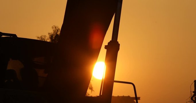 The silhouette of backhoe and sunset, Metal recycle process, backhoe in place to recycle junk, dirty, 