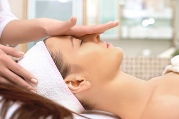 Obraz na płótnie Canvas spa, resort, beauty and health concept - beautiful woman in spa salon getting face treatment