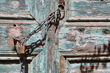 A padlock and chain on an old wooden door