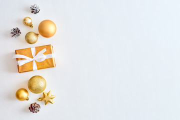 Flat lay christmas border with gold christmas balls and gift box on a white background